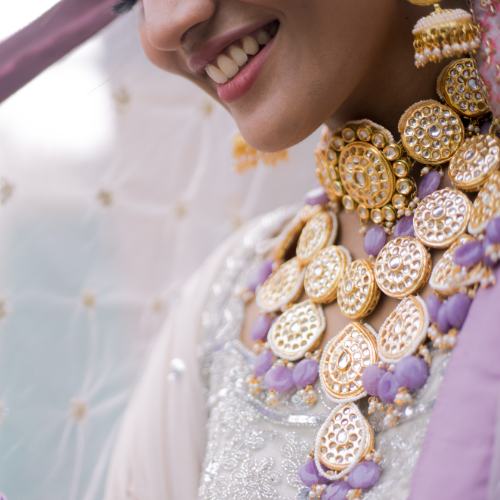 Bride smiling while wearing layered gold jewelry